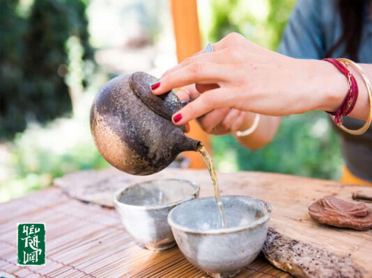 Rót hết nước từ ấm trà vào chuyên