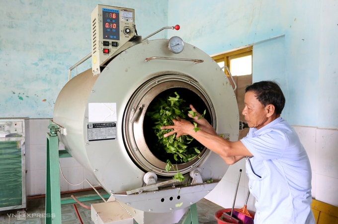Ông Hùng cho chè vào máy chế biến trà. Ảnh: Sơn Thủy